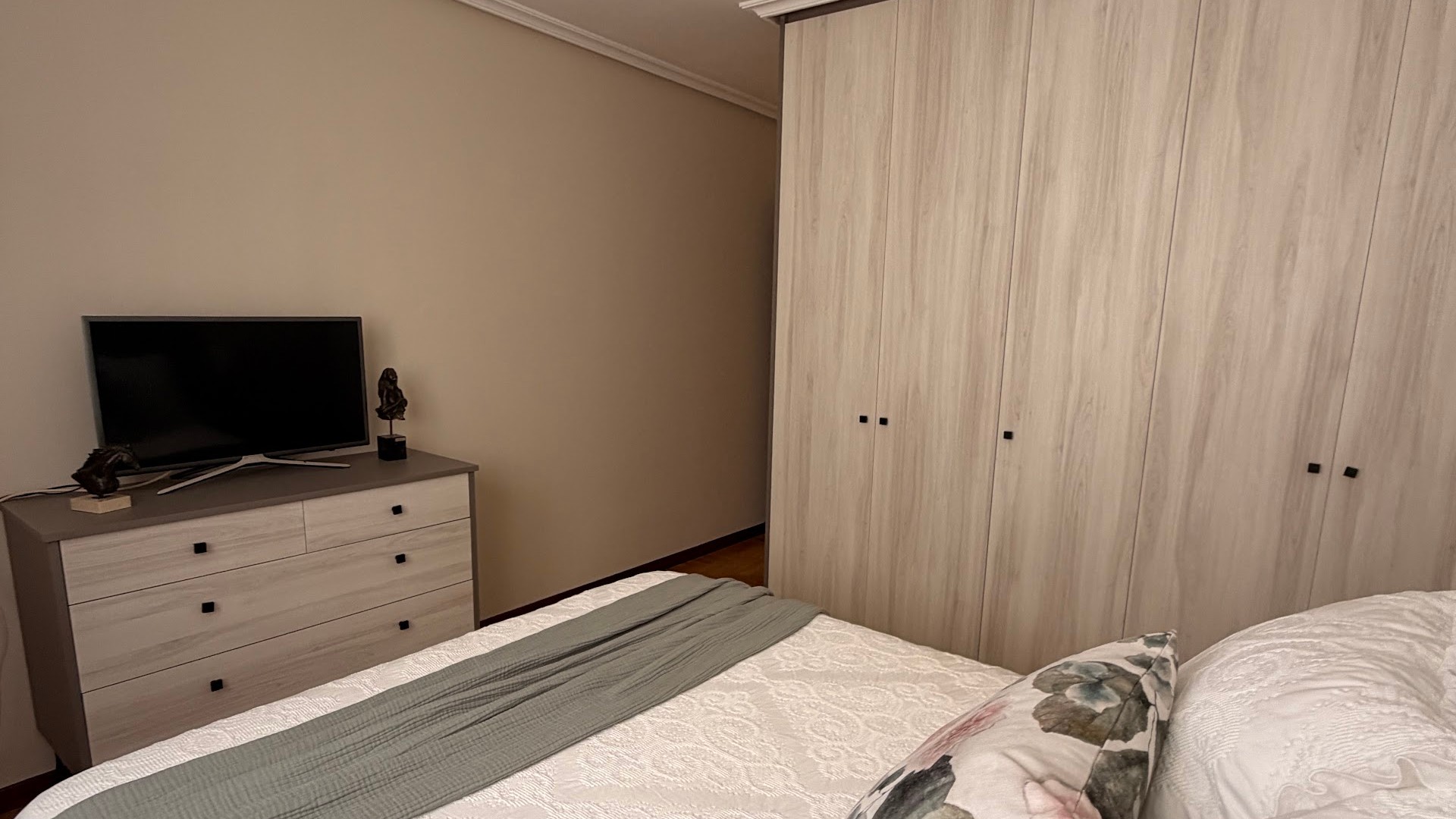 Dormitorio con armario a medida de puertas correderas en tono madera clara