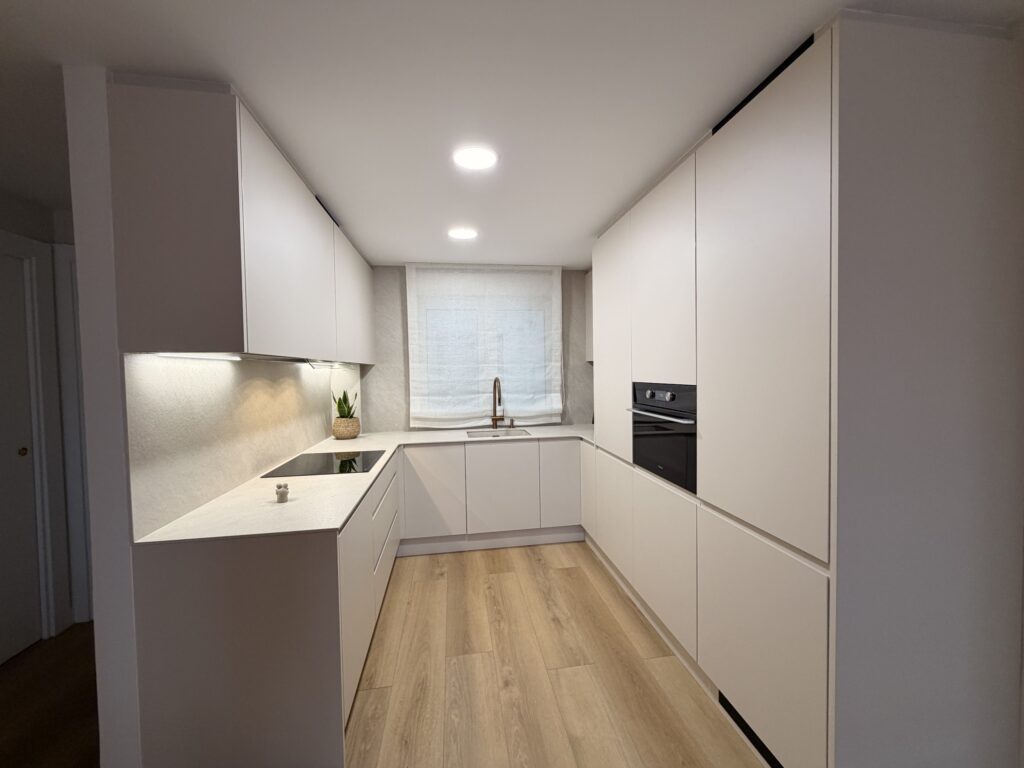 Cocina en U en Jotapet café latte con encimera y pared en porcelánico Ceratop Dina y luz led